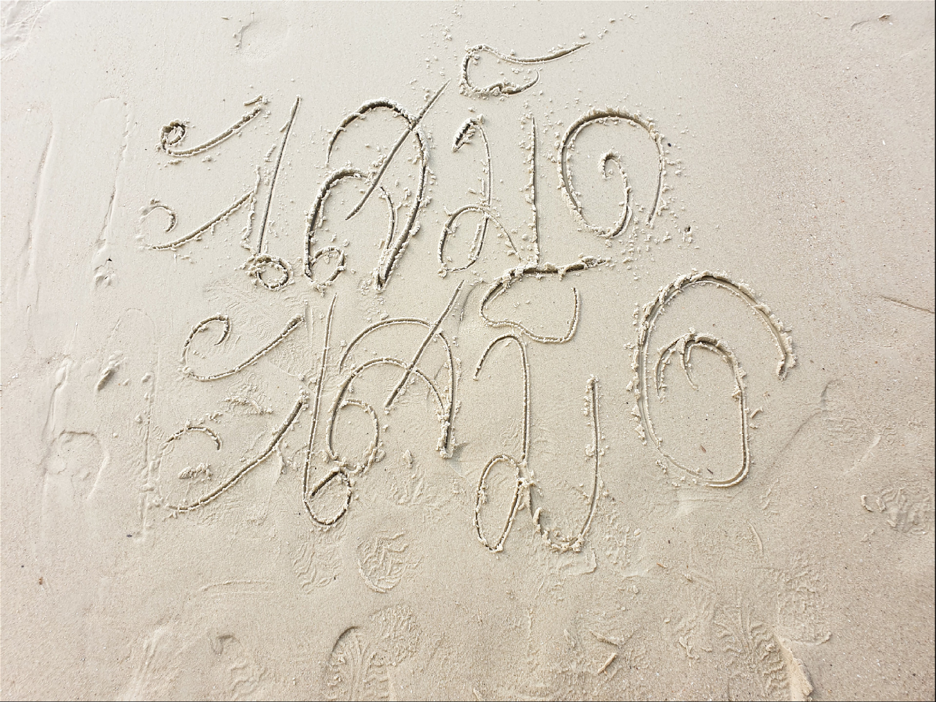 Название острова Самет написанное на песке на тайском языке