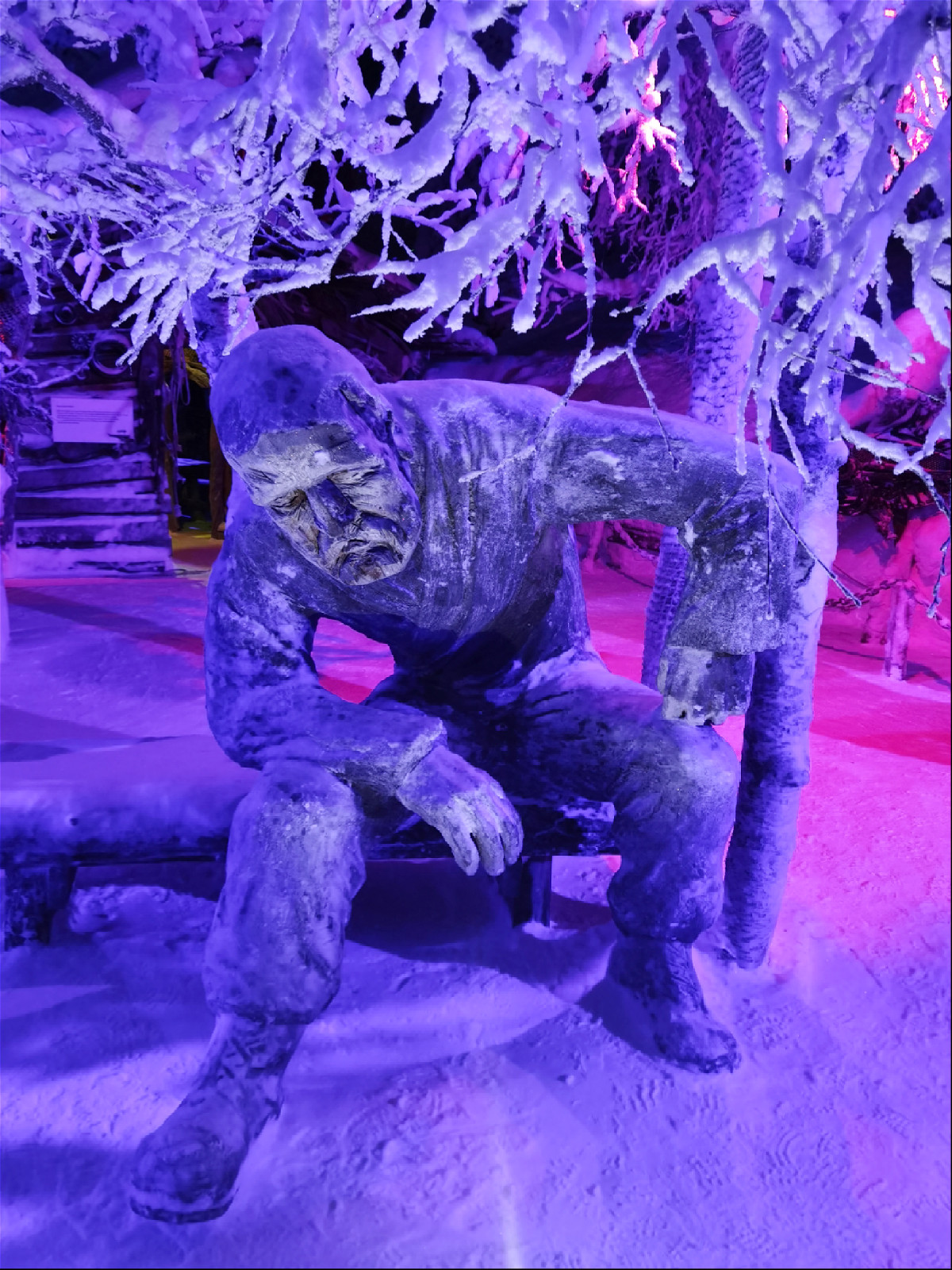 статуя задумавшегося человека сидящего на скамейке в зимнем лесу