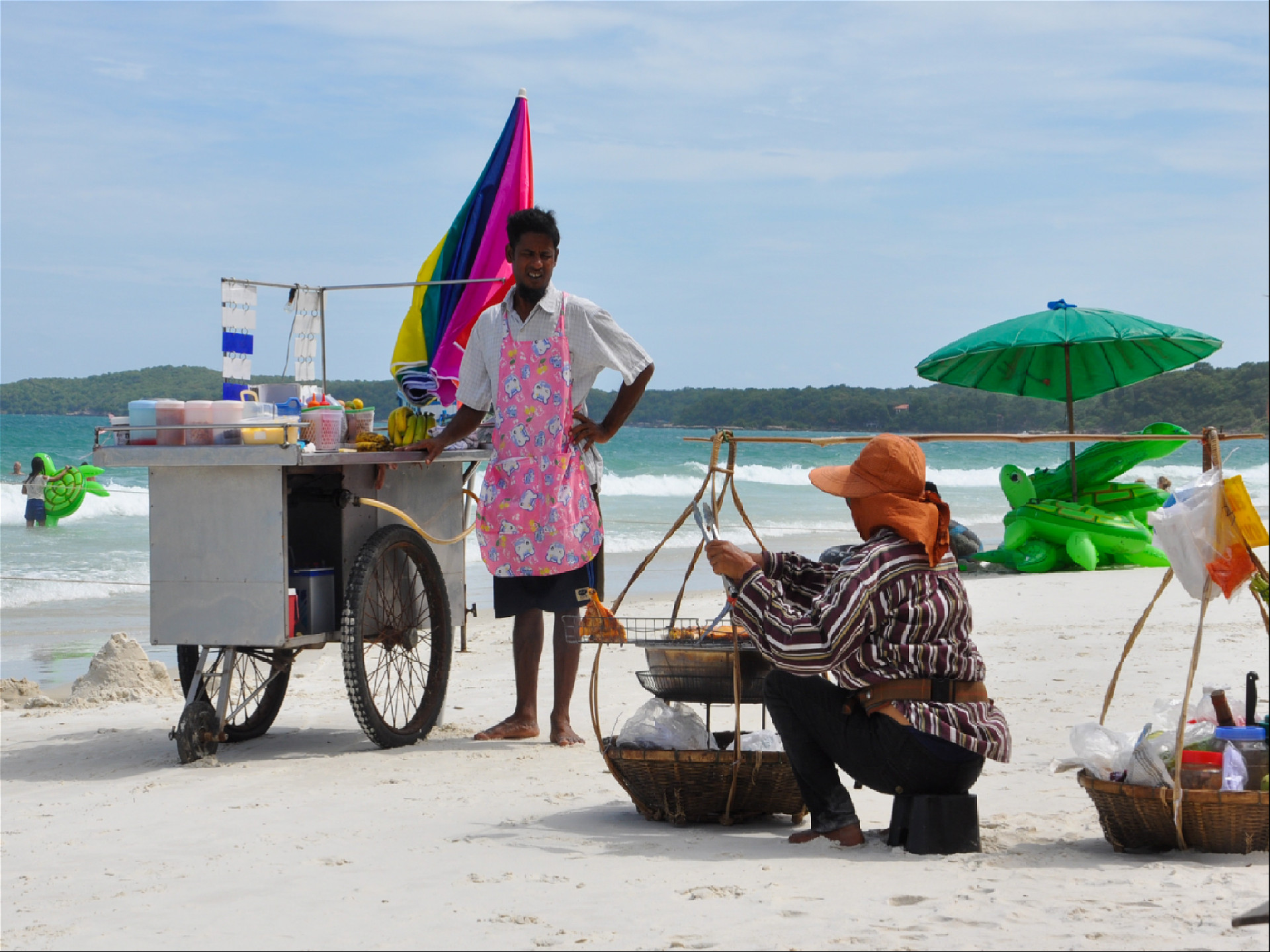 тайские женщина и мужчина с макашницей на пляже торгуют едой