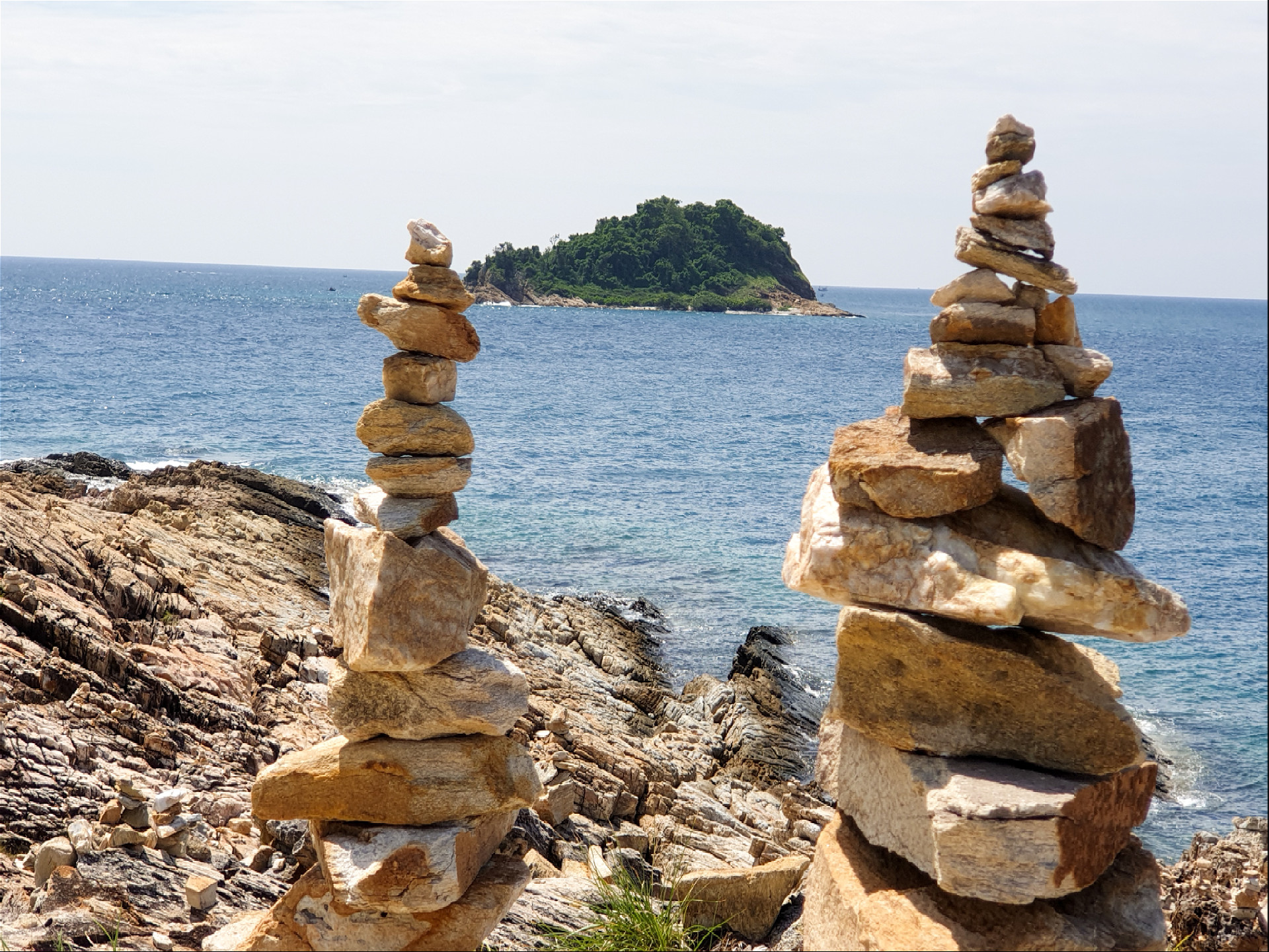 две каменные пирамиды на фоне острова Чан  и моря
