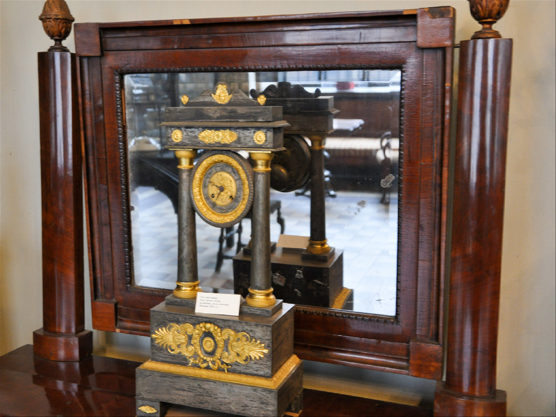 Старинные часы стоящие на зеркале