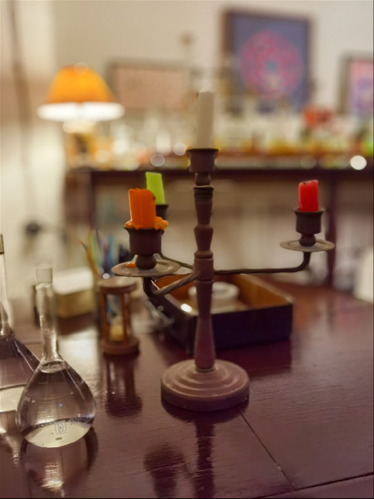 Свечи в подсвечнике и склянки с водой на столе