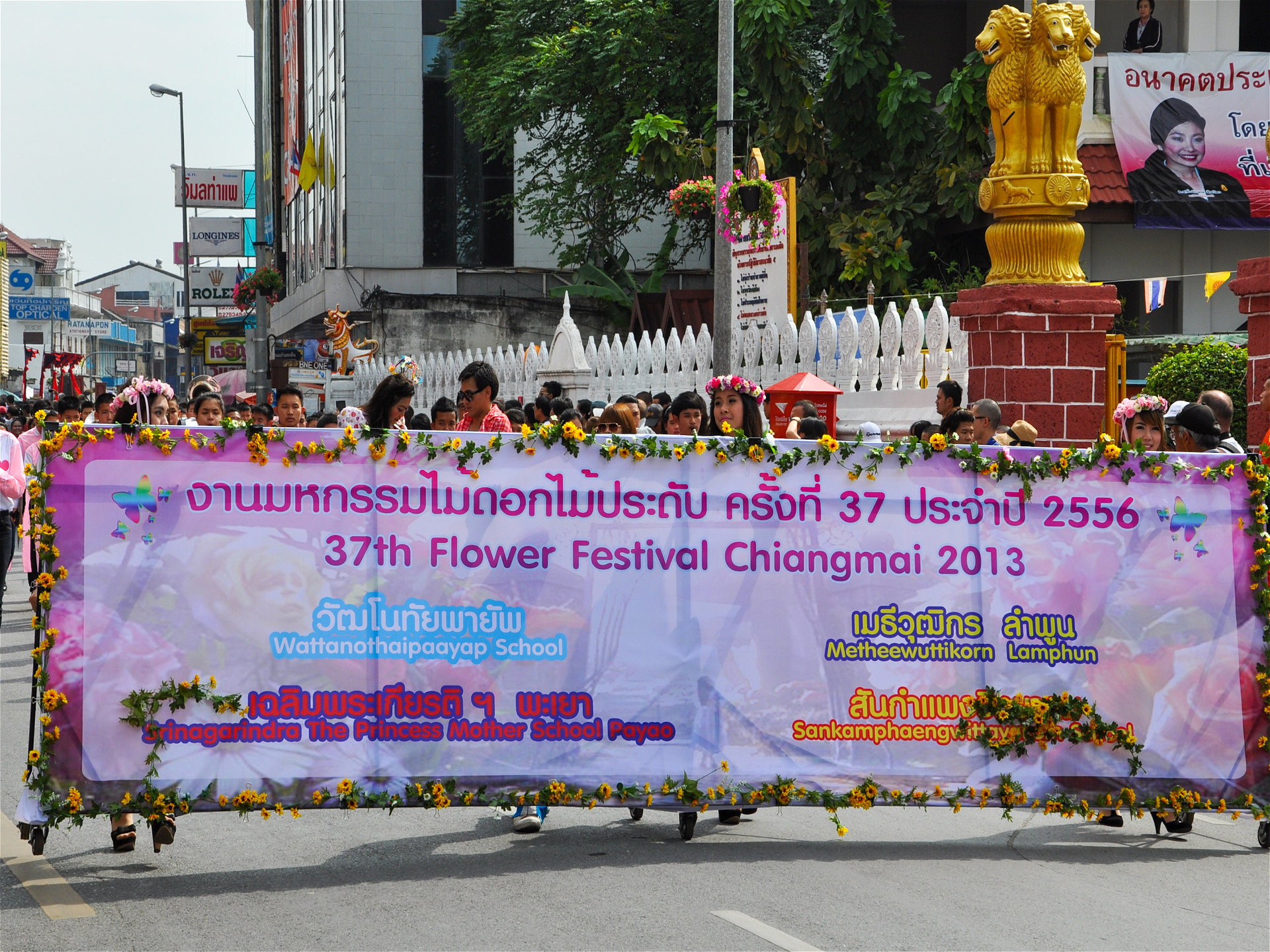 Таицы с транспарантом 37й фестиваль цветов Чиангмай