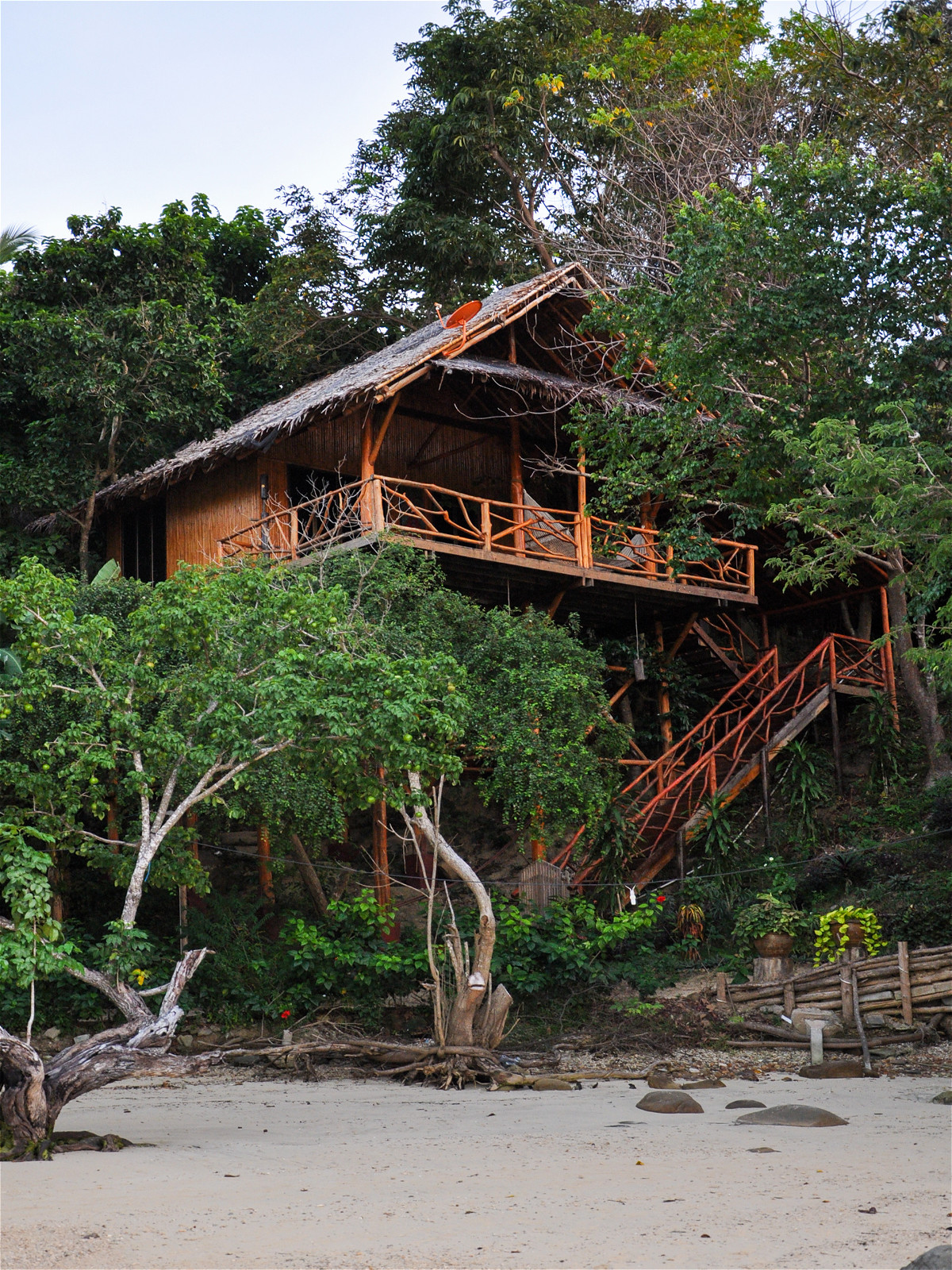 Двухэтажный деревянный дом на пляже в лесу