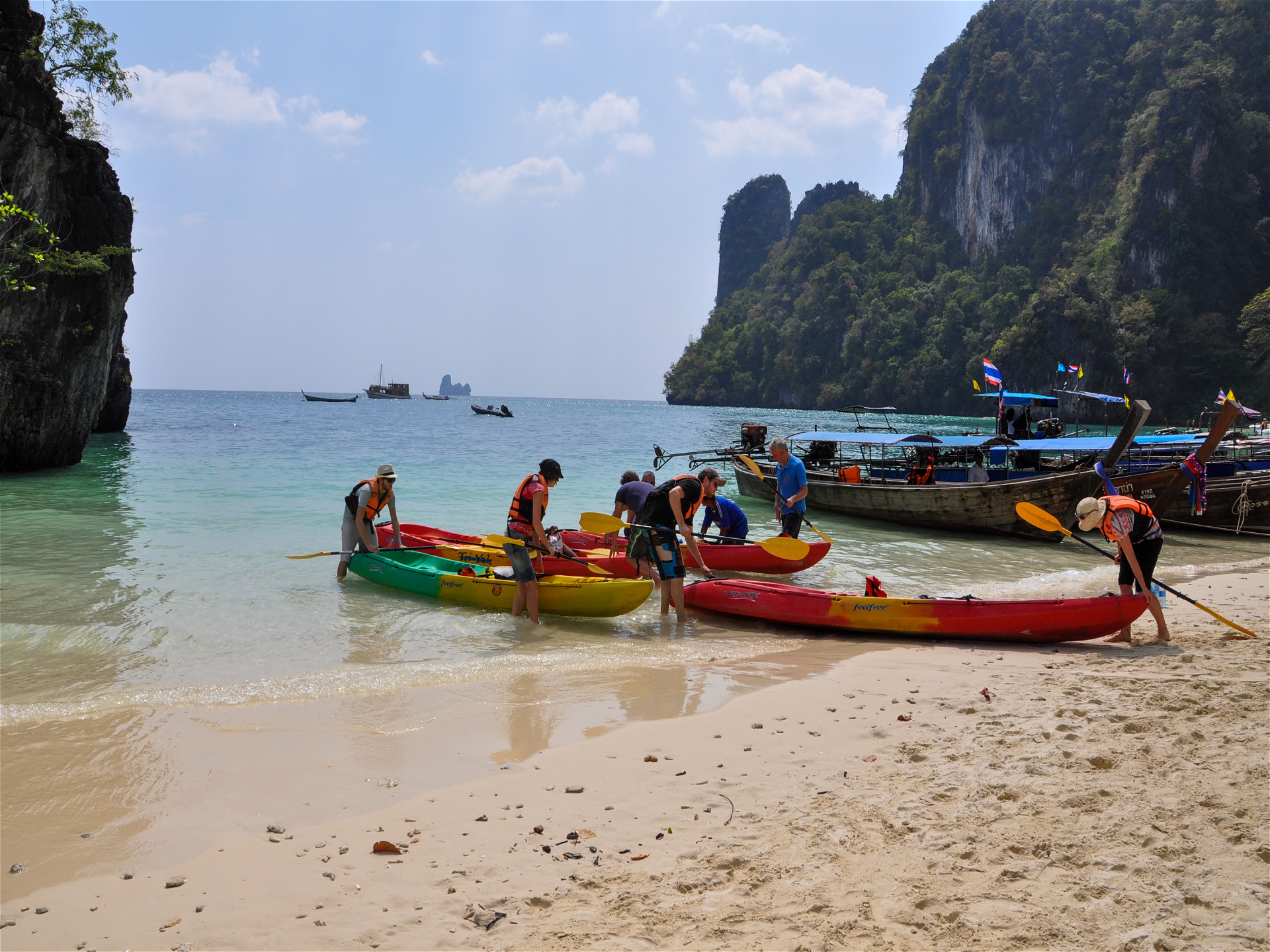 Туристы причаливают в лодках на пляже