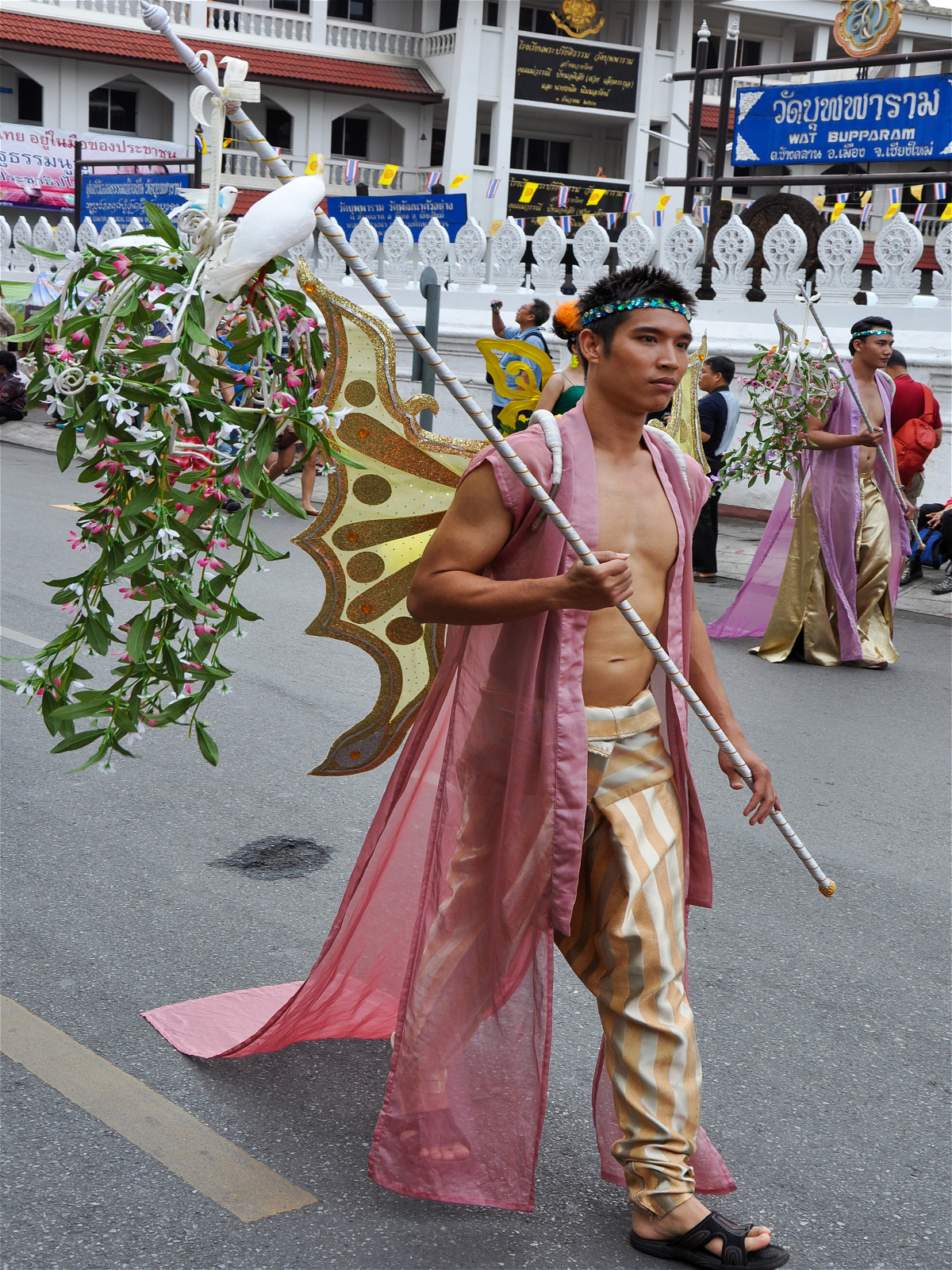 парень азиат с палкой и крыльями на улице