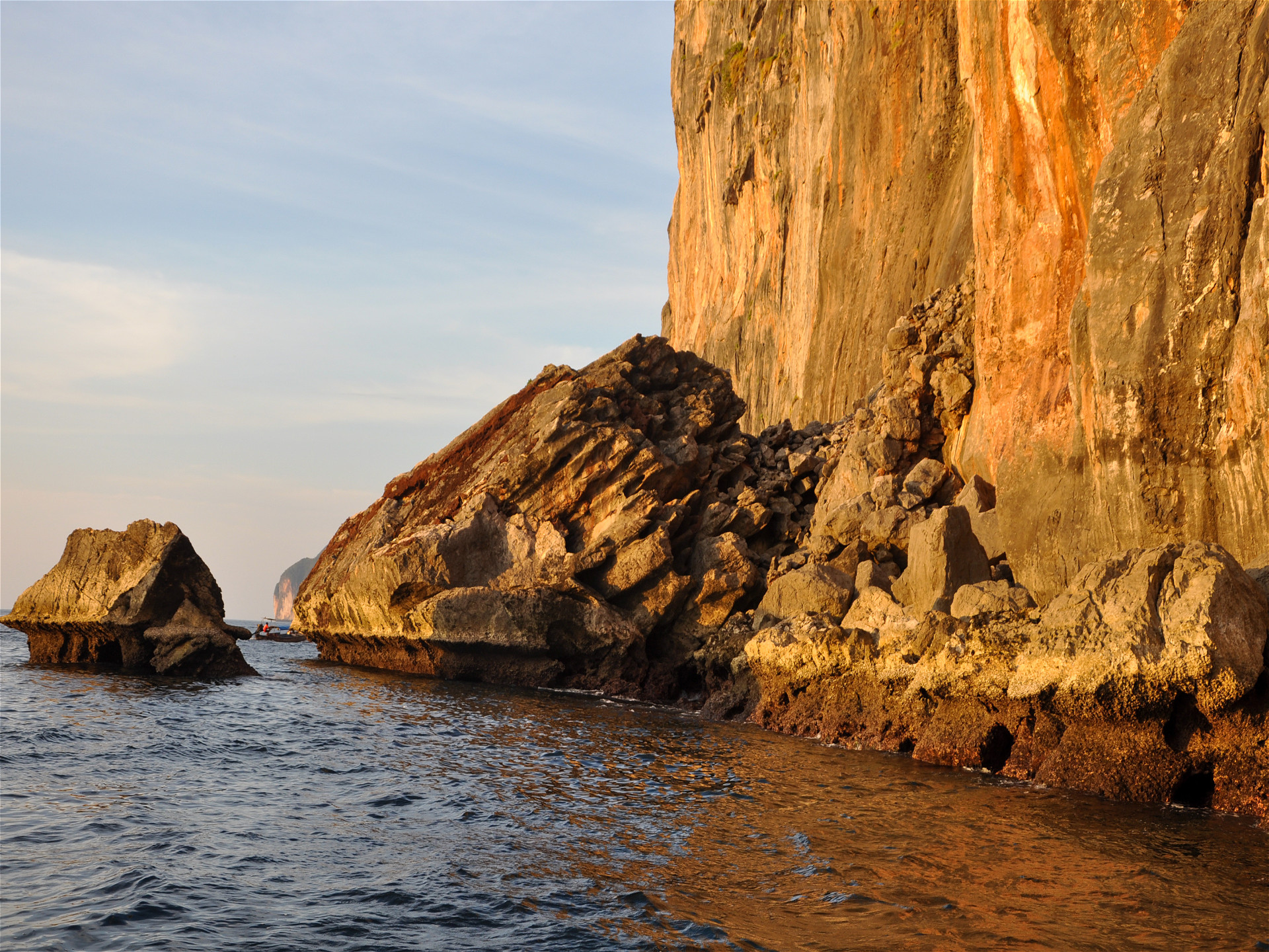 гигантские обломки скал в море освещены закатным солнцем