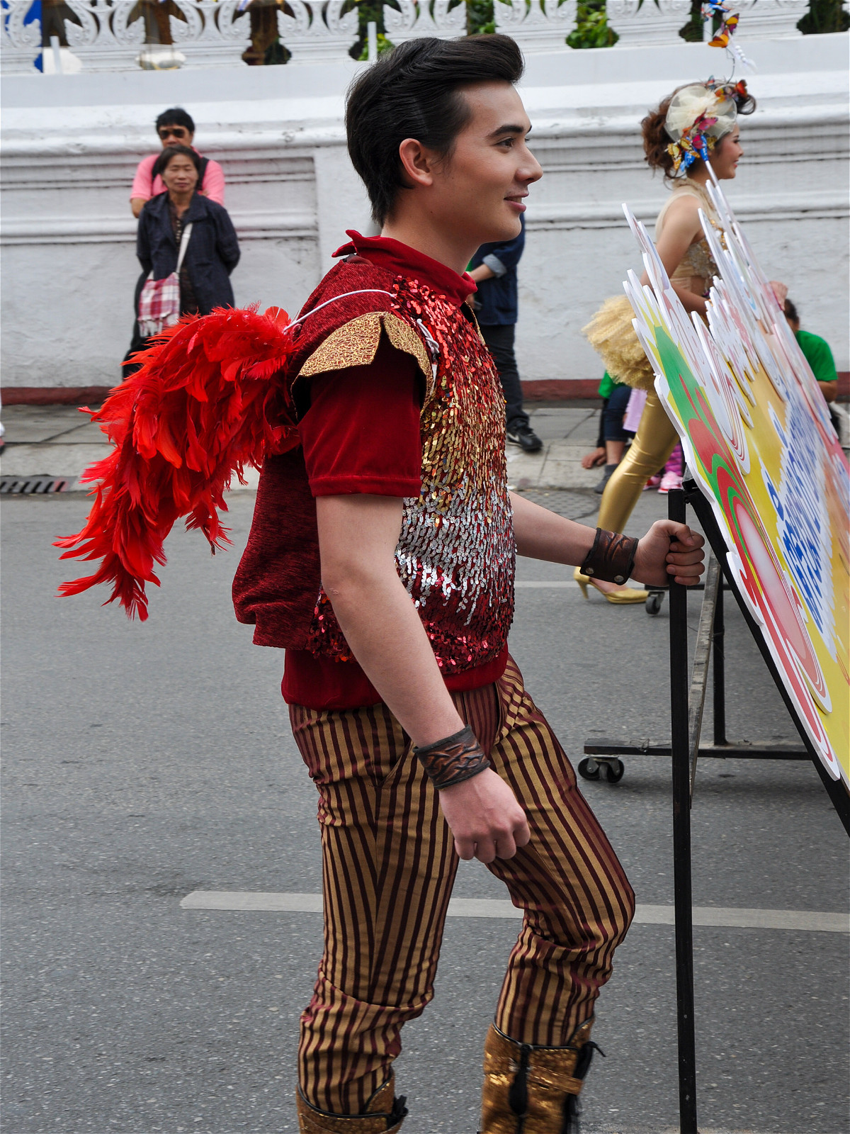 парень таец с крыльями на фестивале цветов
