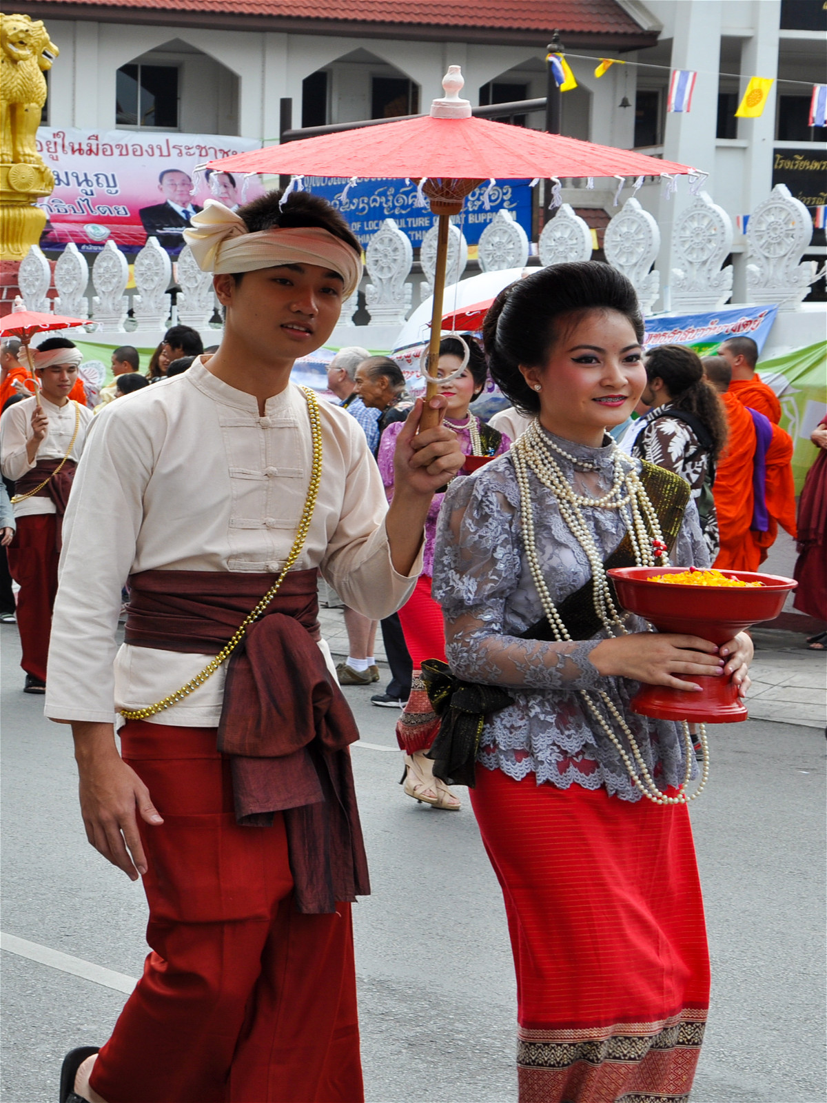азиаты под зонтиком в традиционных одеждах